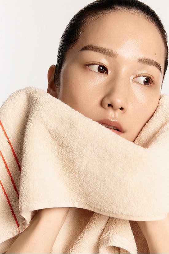 A model wiping her face with a towel